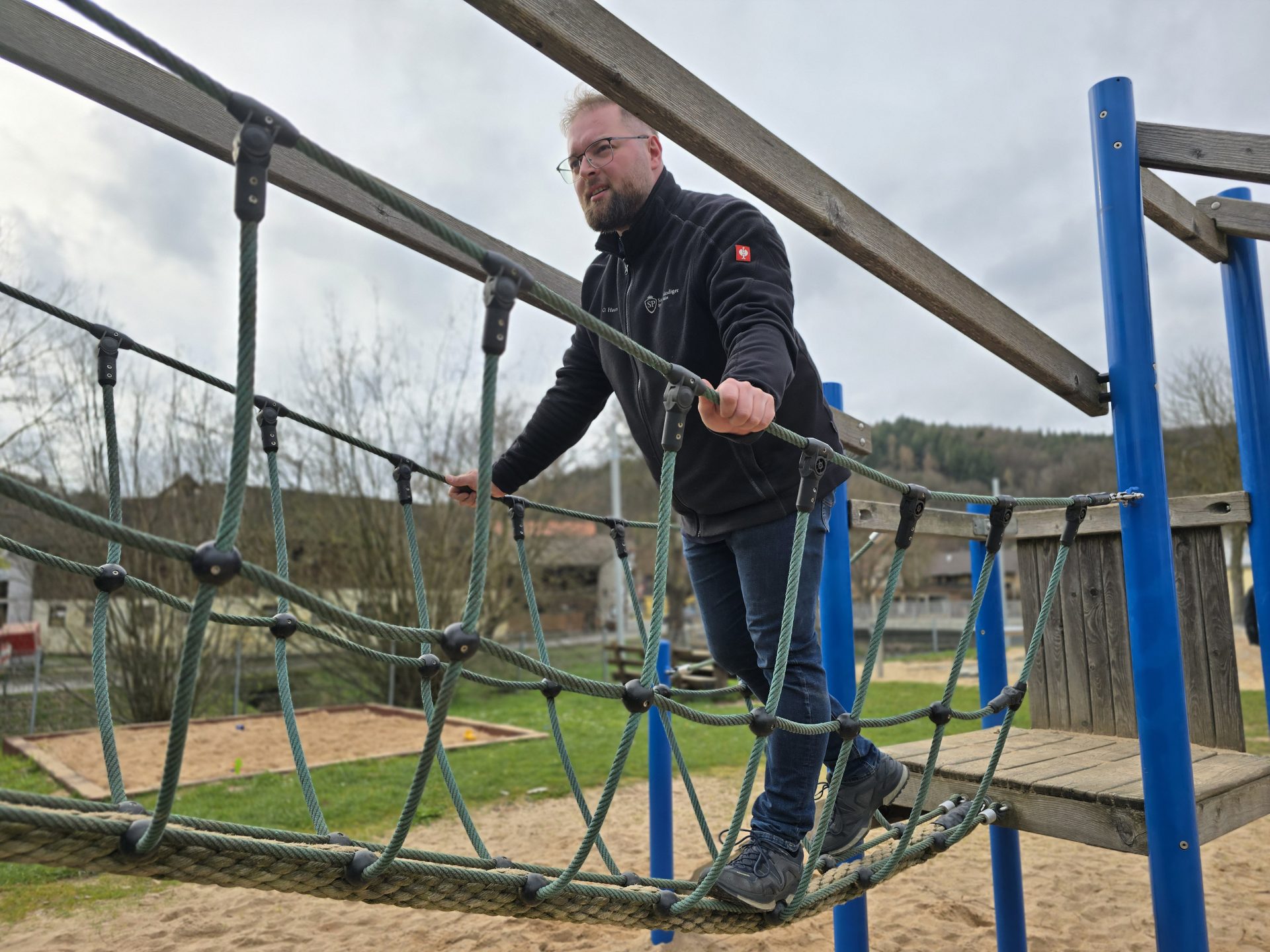Teilnehmer bei der Prüfung eines Spielplatzgeräts