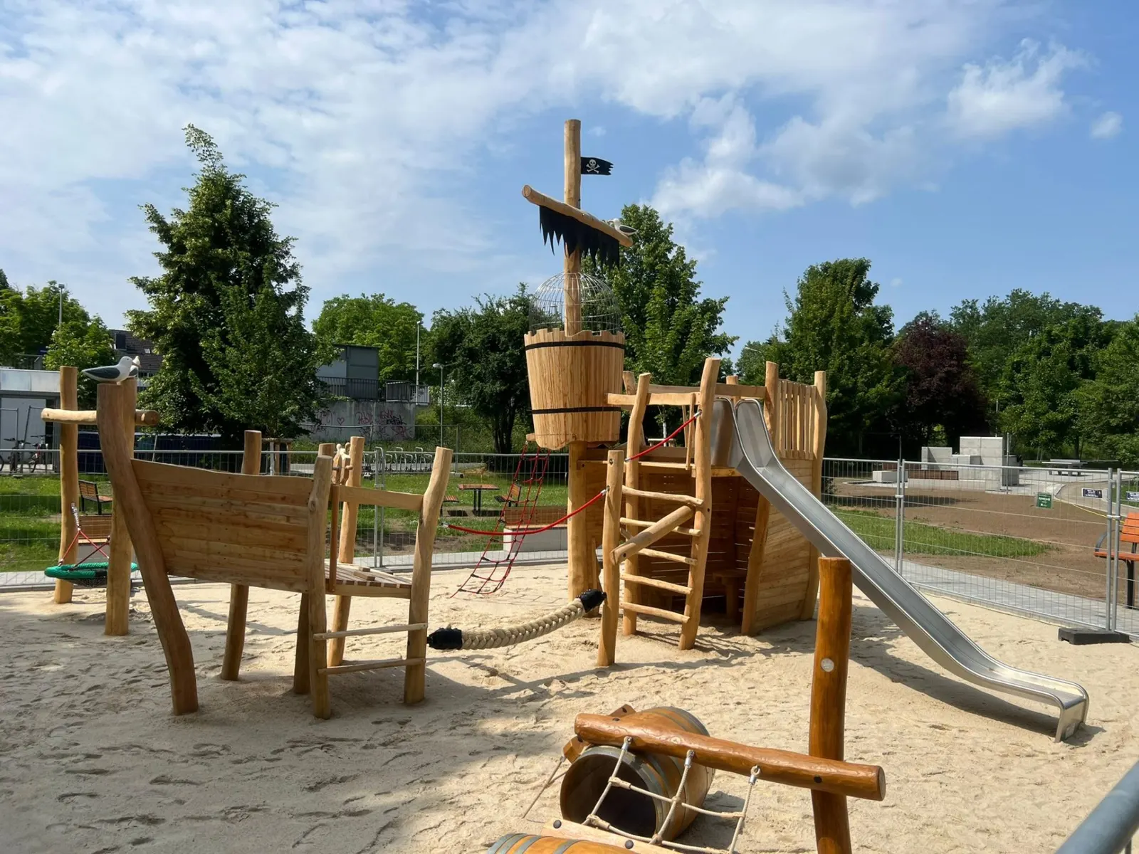 Spielplatz mit hölzernem Spielschiff und Rutsche